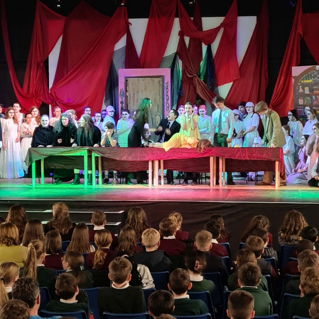 The Addams Family on stage with primary school audience