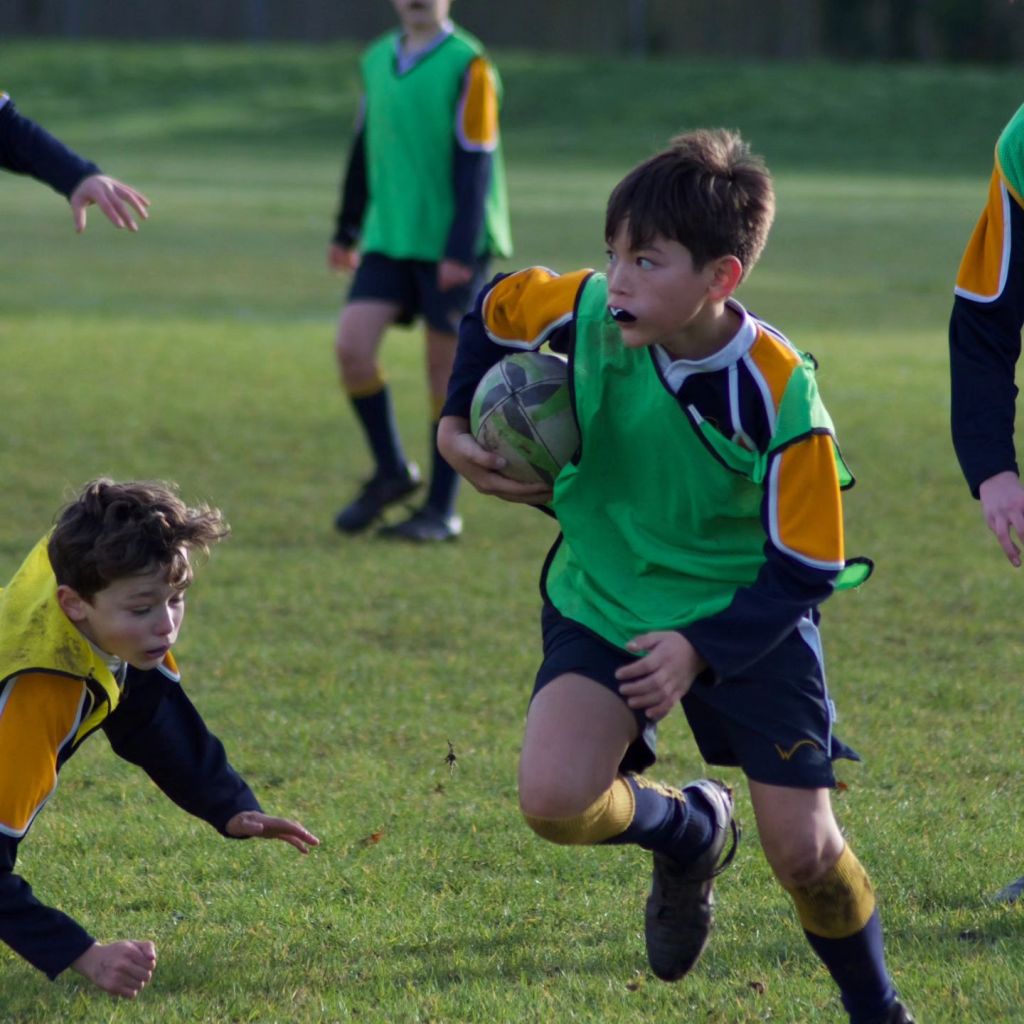 A student running with a rugby ball