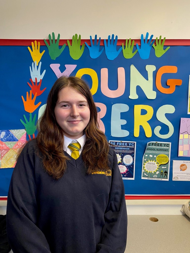 Young girl standing in front of a board saying young carers